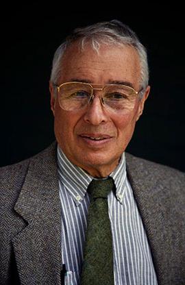 headshot of man with coat and tie, glasses