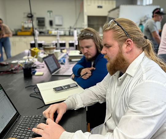 two men, with beards, looking at a laptop