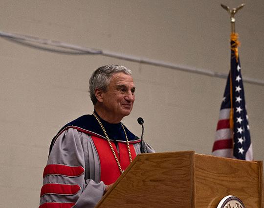 man with robe speaking at a podium